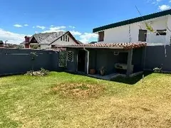 Jardín amplio con pérgola y área de parrilla