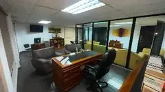 Sala de gerencia con escritorio y ventanal