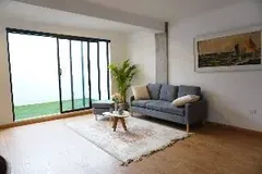 Sala amueblada con ventanal de piso a techo